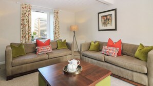 A living room with two sofas, a coffee table, and a framed picture on the wall. - 1 Deuchrie Cottages (Dunbar)