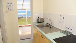 Une cuisine avec vue sur la mer, un grille-pain, un évier et une cuisinière.