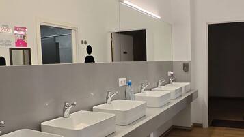 A modern bathroom with multiple sinks and a large mirror.