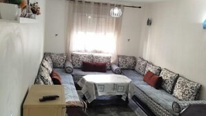 A compact living space with a sofa set, a small table, and a cabinet.