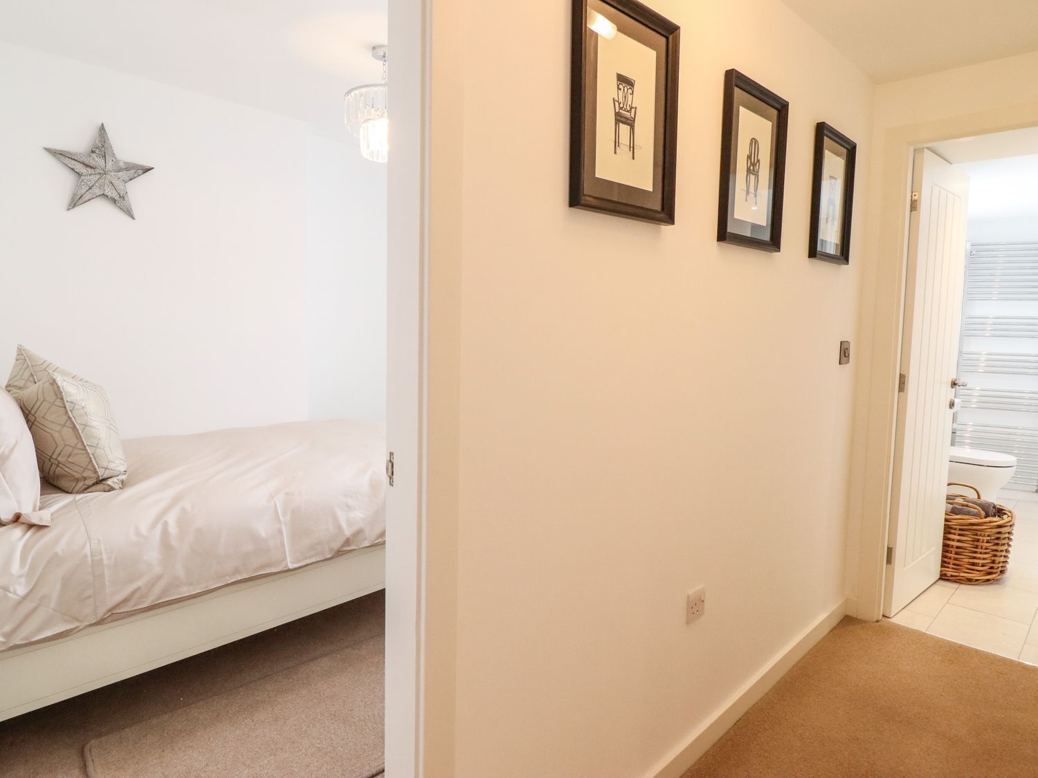 A bedroom with a bed, a star decoration, and three framed pictures on the wall.