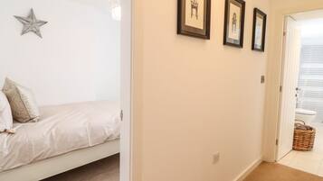 A bedroom with a bed, a star decoration, and three framed pictures on the wall.
