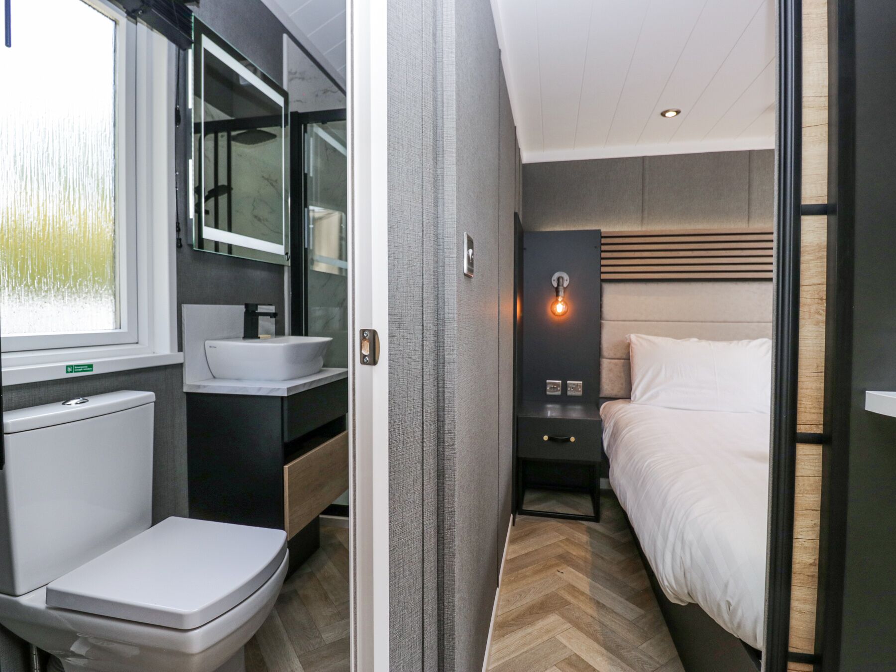 A modern bathroom with a toilet, sink, and mirror.
