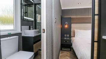 A modern bathroom with a toilet, sink, and mirror.