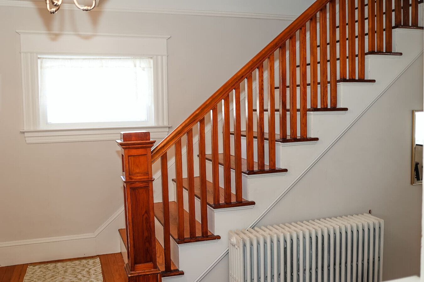 A staircase with wooden balusters and a white radiator below.