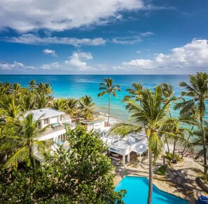 A resort with a pool, palm trees, and a view of the ocean. - Kite Beach Hotel (Cabarete)