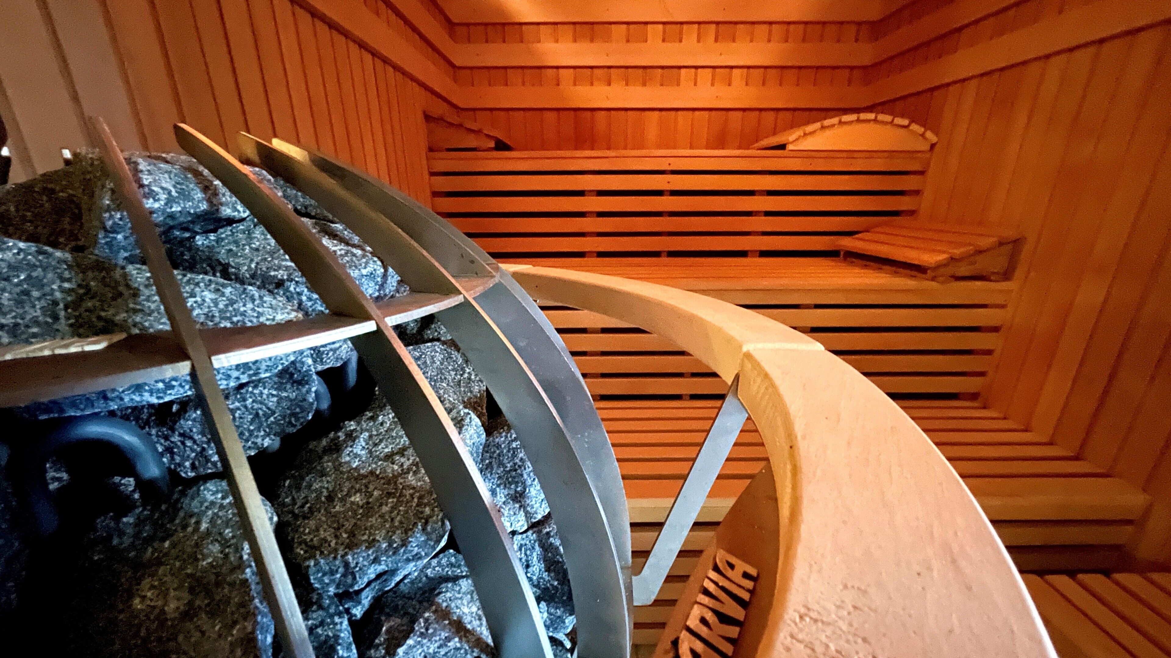 Una sauna con bancos de madera y una estructura metálica en el centro.