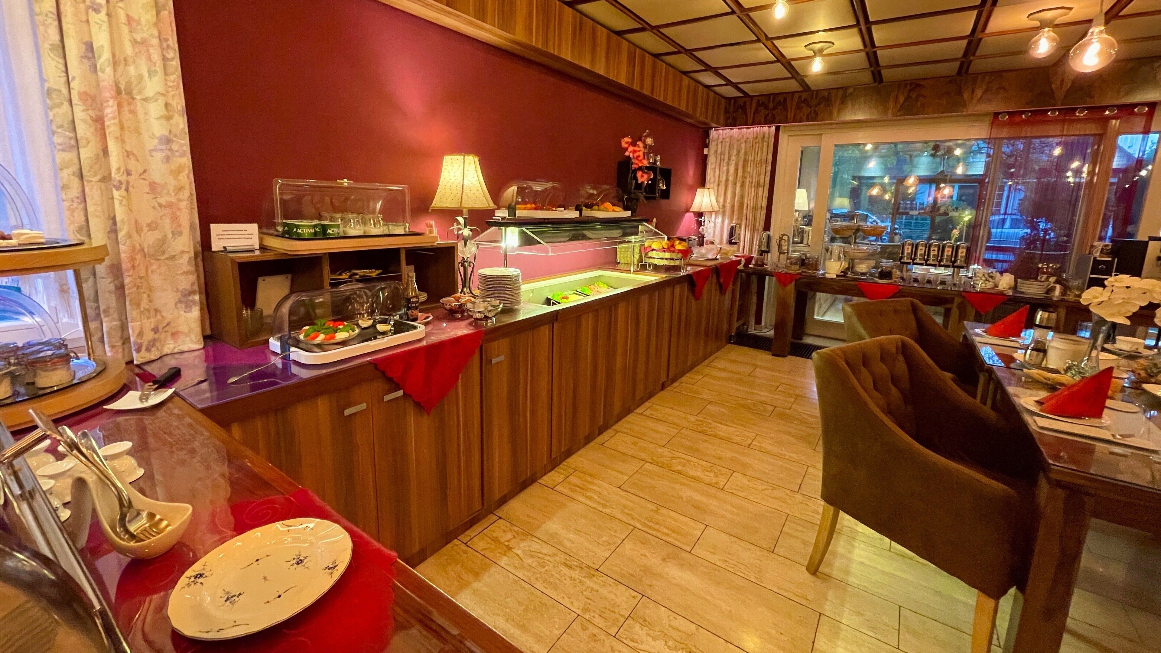 Ein Restaurant mit Holzauslage, einer Glastheke und einem Essbereich mit Stühlen und Tischen.