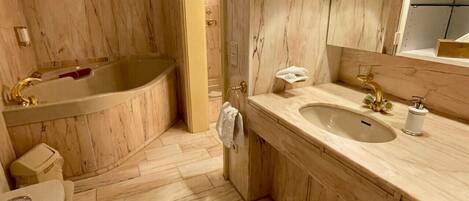 A bathroom with a freestanding bathtub, a sink, and a mirror.