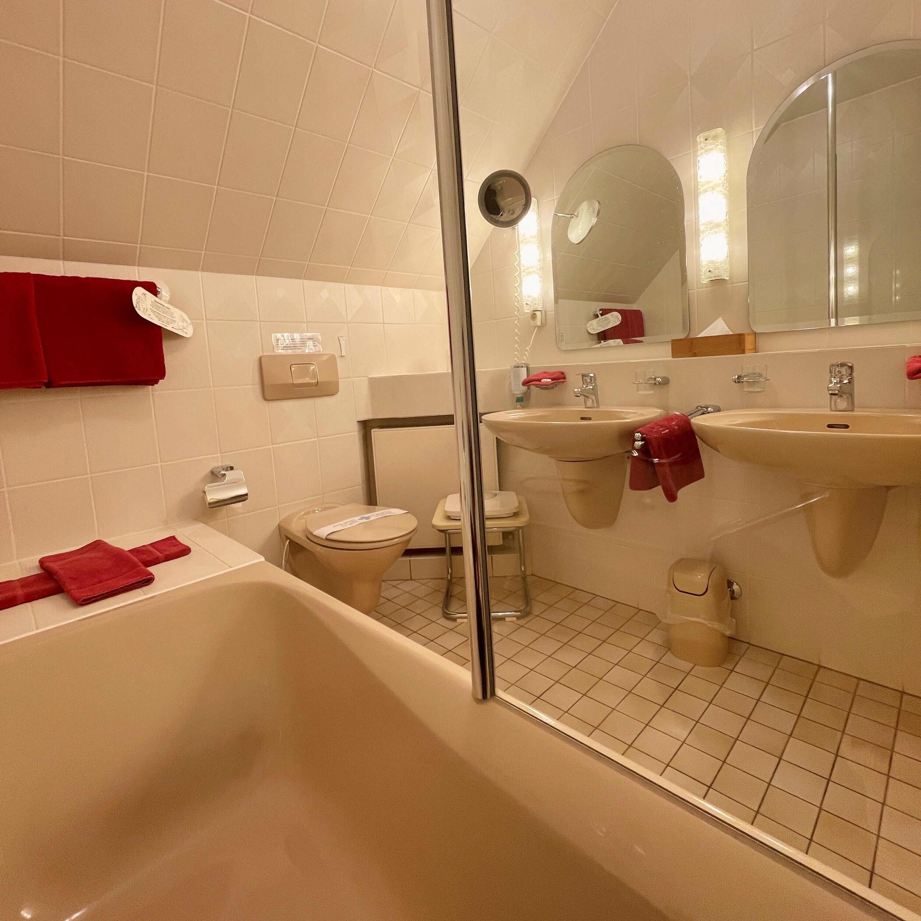Un baño con bañera, dos lavamanos, inodoro y cabina de ducha de vidrio.