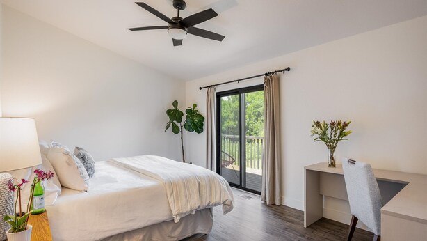 A bedroom with a bed, a desk, and a chair. There is a window with curtains and a view of greenery outside. - Exquisite Group Retreat, 15-min to Downtown Boulder (Boulder)