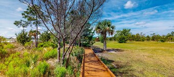 Palm-lined home with dock access, firepit & inviting balconies