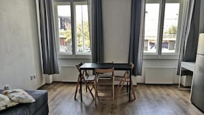 Una habitación con una mesa y sillas de madera, un sofá y un radiador.
