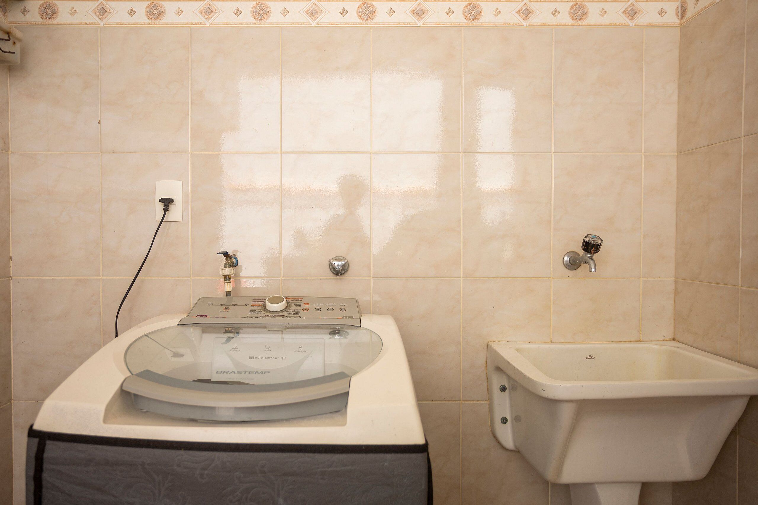 A bathroom with a washing machine, a sink, and a toilet.
