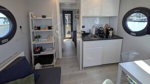 A compact kitchen with a sink, cabinets, and a window. - Cosy Houseboat `Eclipse` in Marina Monnickendam (Monnickendam)