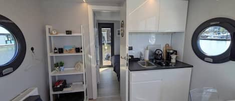 A compact kitchen with a sink, cabinets, and a window.