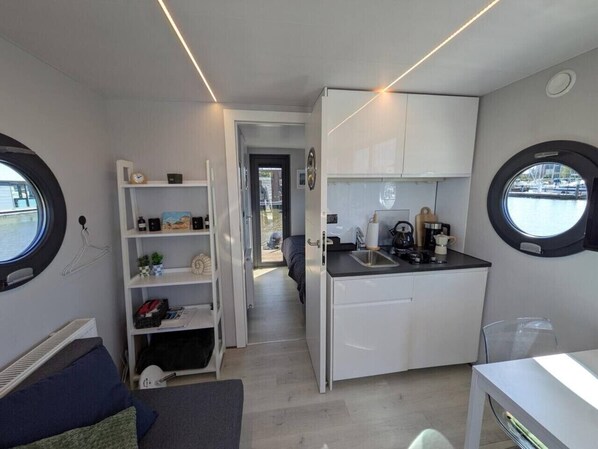 A compact kitchen with a sink, cabinets, and a window.