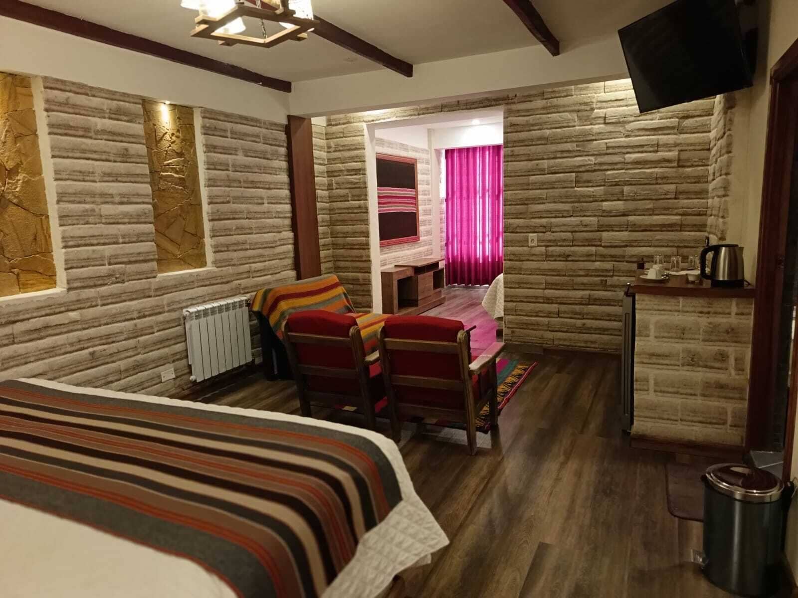 Ein gemütliches Zimmer mit einem Bett, einem Schreibtisch und einem Fernseher.