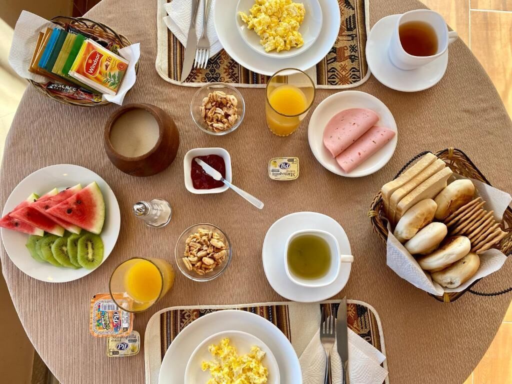 A breakfast table with various food items and drinks.