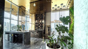 Un interior moderno con piso de mármol, una zona de cocina y un amplio ventanal con vista a la ciudad.