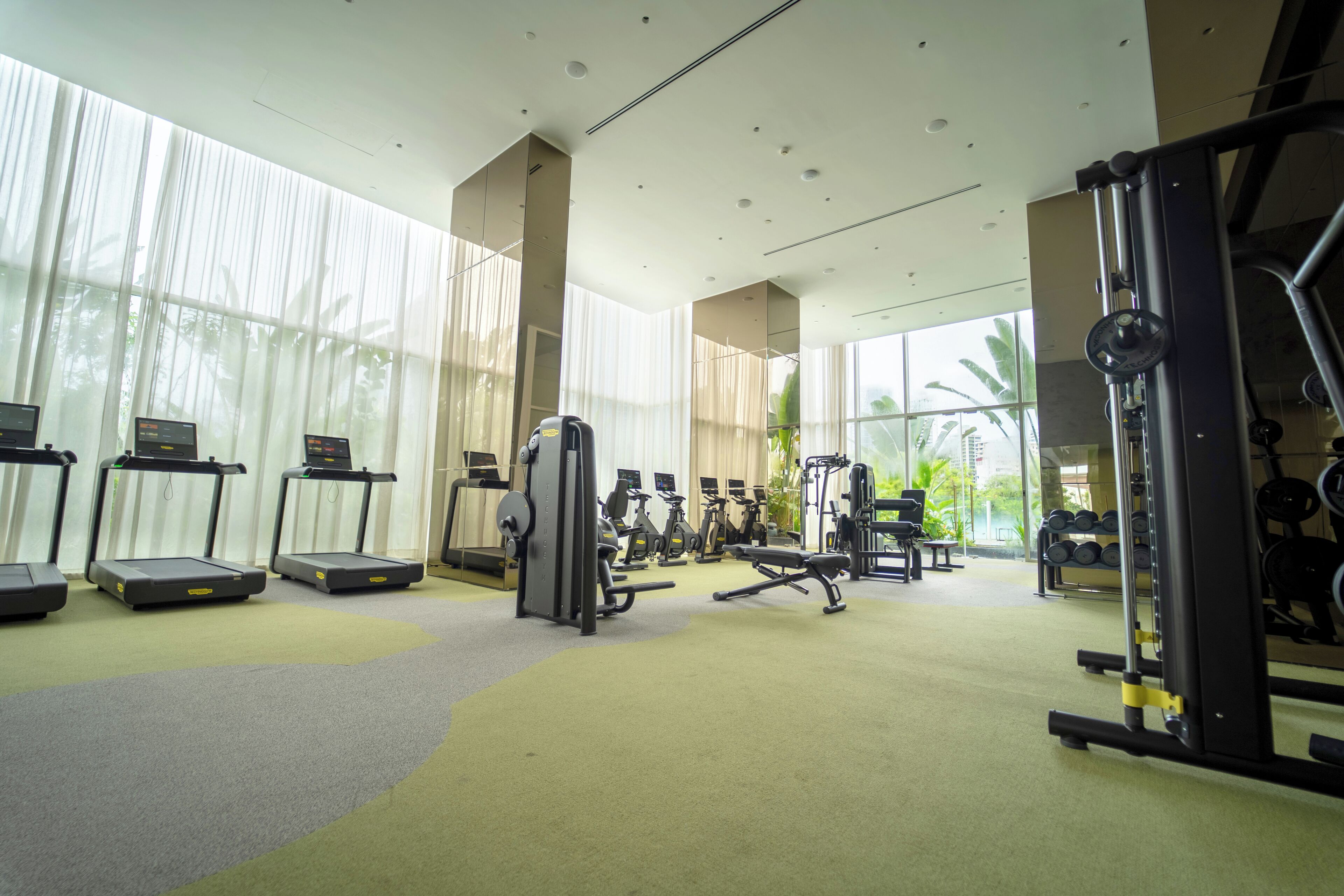 Un gimnasio moderno con cintas de correr, máquinas de pesas y equipo de cardio.