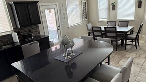 A modern kitchen with a large island, dining area, and built-in appliances. - Westside spot near the Outlet Mall and Providence Hospital, with easy I-10 acces (El Paso)