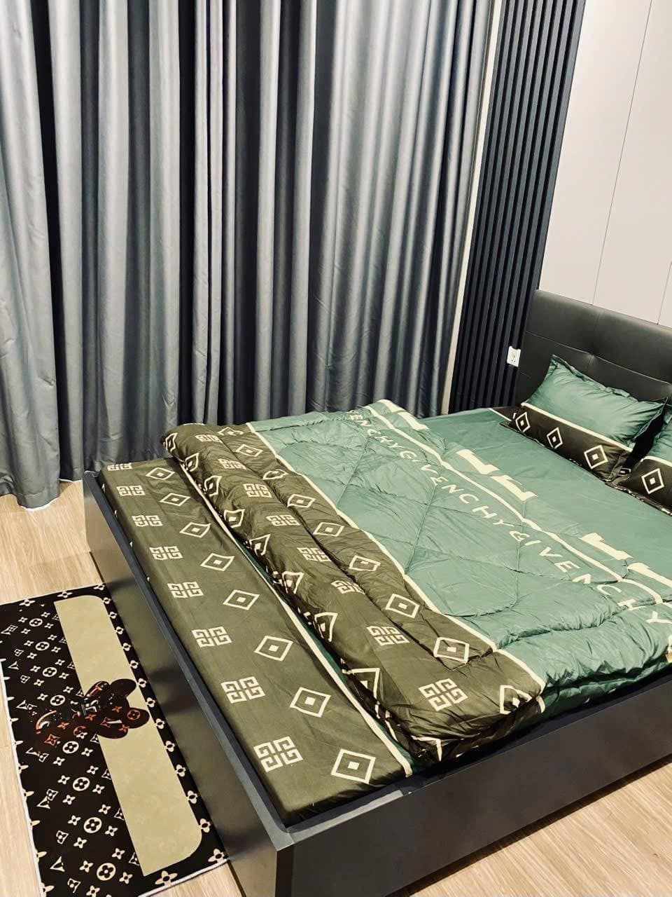 A bedroom with a bed, curtains, and a rug.
