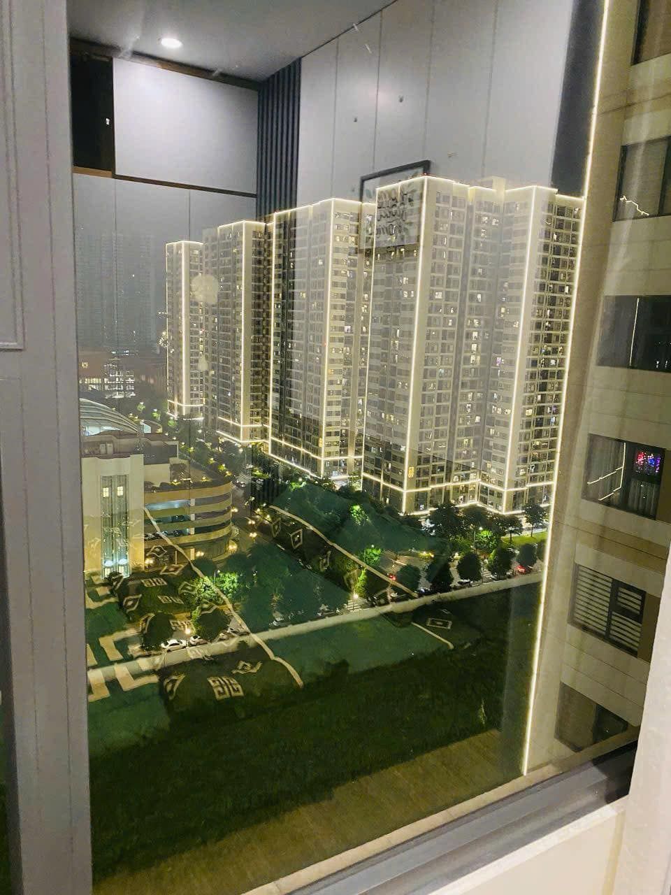 Un edificio alto con varios pisos, ventanas grandes y fachada bien iluminada.