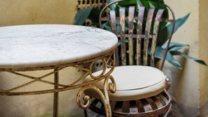 A round table with a marble top and a metal chair with a cushioned seat. - Residenza Pinzochere (Firenze)