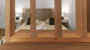 A bedroom with a bed, nightstands, and a wooden headboard.
