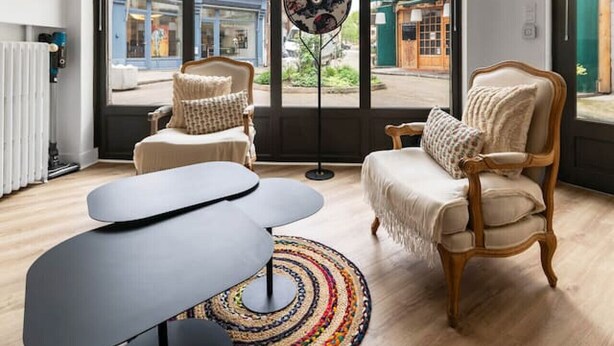 A modern living room with a large window, a round floor lamp, and two armchairs. - Maison design hyper centre - Triangle d'or (Vichy)