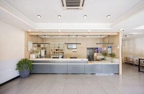 Et receptionsområde med disk, siddepladser og en potteplante.