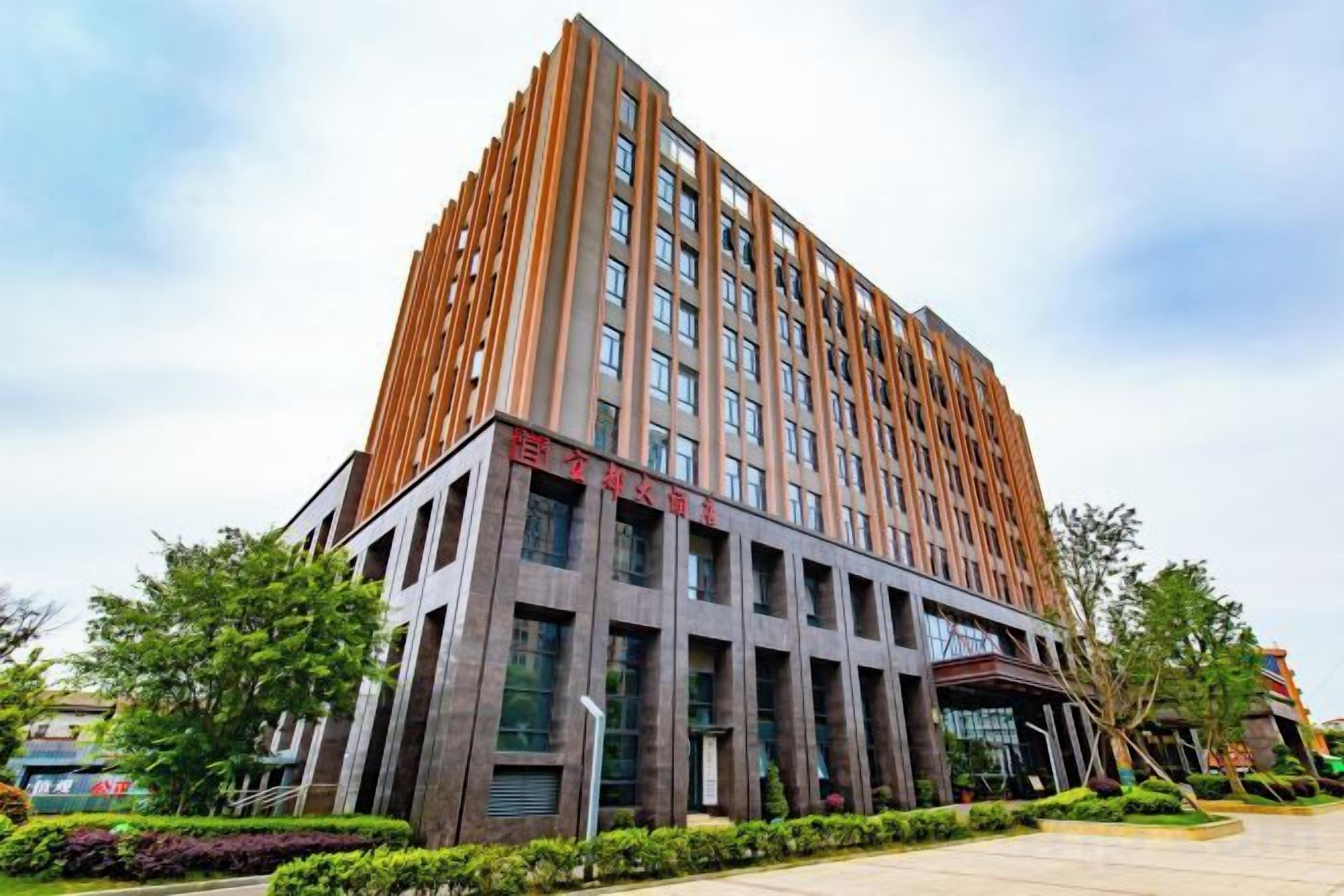 A multi-story building with a modern architectural design, featuring a prominent entrance with glass doors and a flat roof.