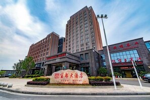 A hotel with a prominent entrance, a large sign, and a modern building facade. - Yi Du Hotel (Yidu)