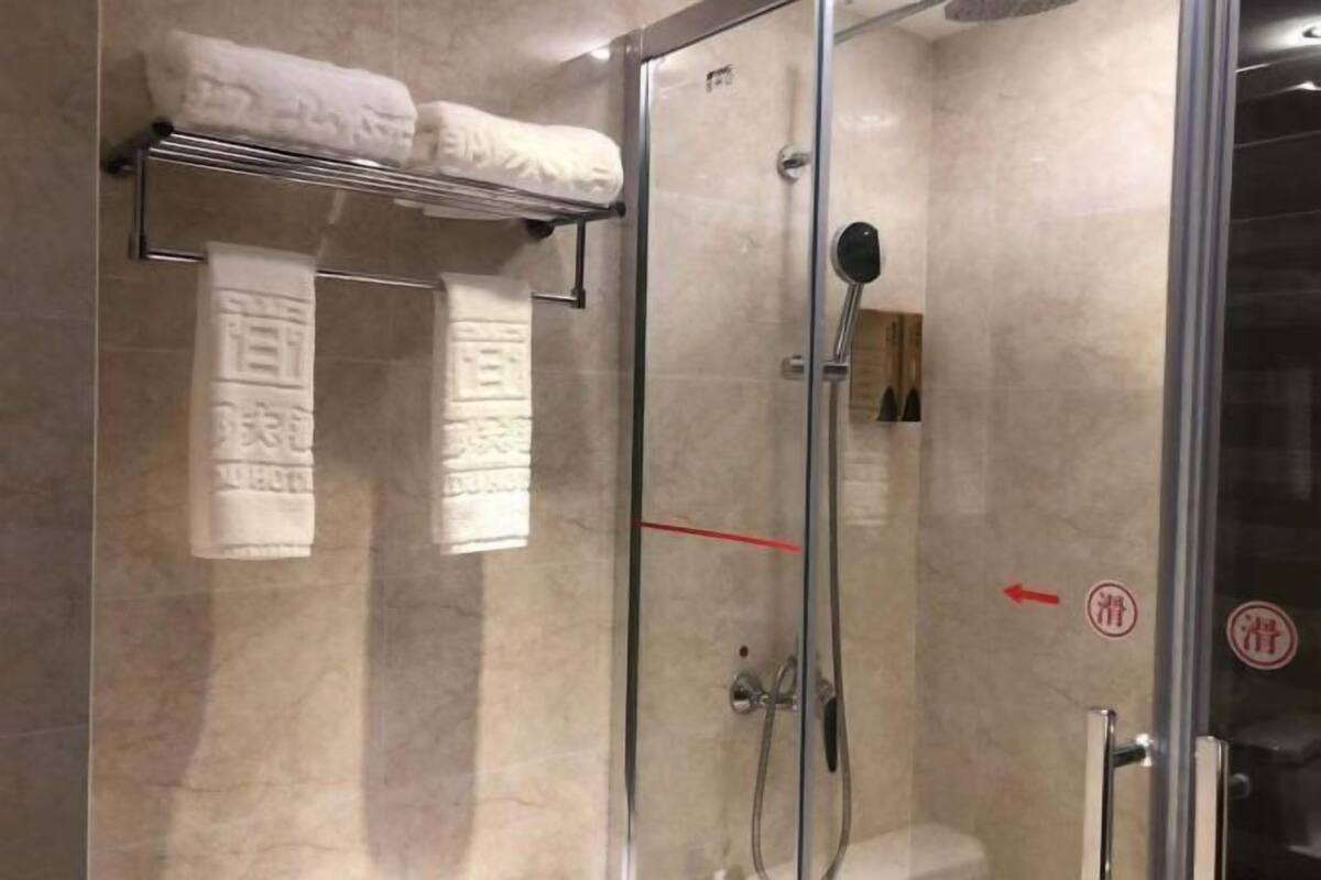 Eine begehbare Duschkabine mit Handbrause und einem Händetuchhalter darüber.