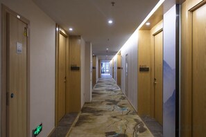 A hotel corridor with wooden doors, a patterned carpet, and a sign indicating room number 410. - Yi Du Hotel (Yidu)