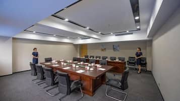 A conference room with a long table, chairs, and a carpeted floor.