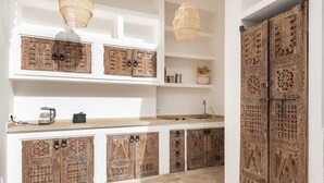 A modern kitchen with intricate wooden cabinetry, a built-in sink, and a hanging light fixture. - Luxurious 6-bedroom private riad with pool and AC in Marrakesh - Aubiane 88 (Marrakech)