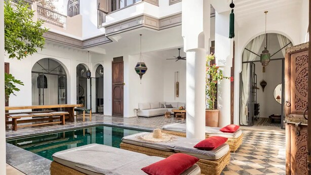 A poolside area with lounge chairs, a bench, and a ceiling fan. - Luxurious 6-bedroom private riad with pool and AC in Marrakesh - Aubiane 88 (Marrakech)