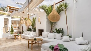 A modern living room with a white sofa, a wooden coffee table, and hanging rattan lamps. - Luxurious 6-bedroom private riad with pool and AC in Marrakesh - Aubiane 88 (Marrakech)