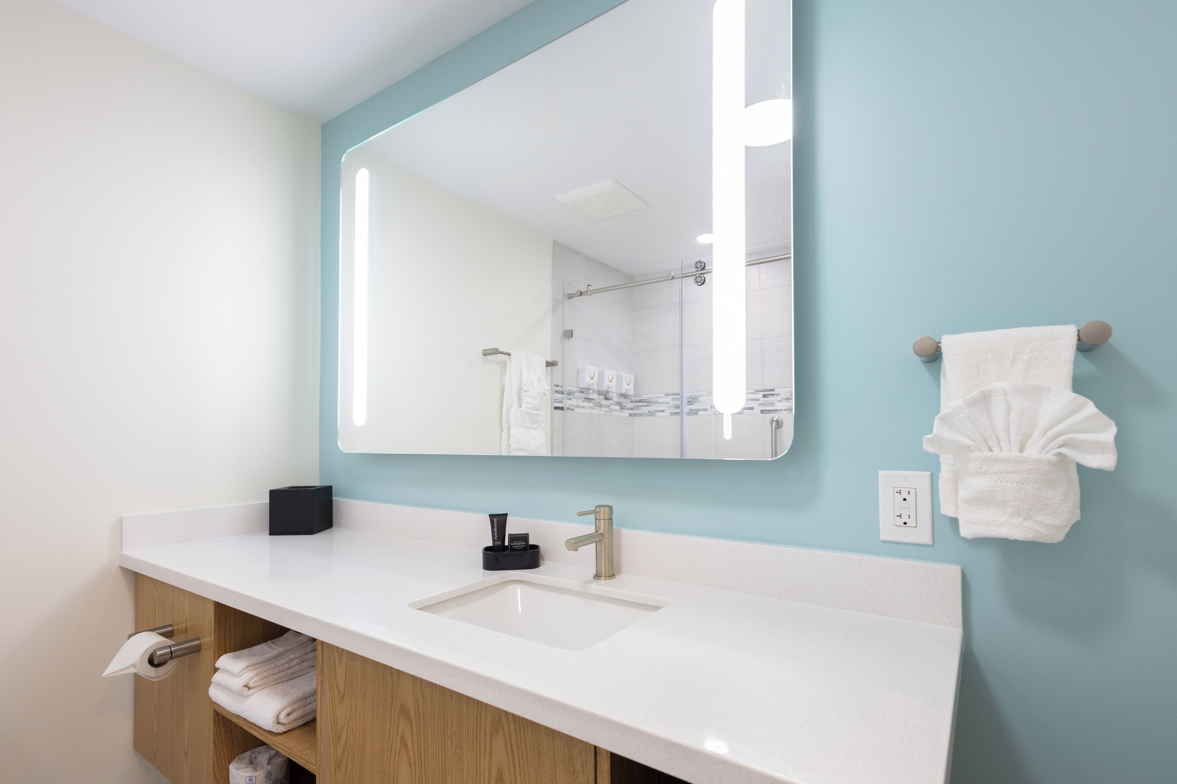 Une salle de bain avec un lavabo blanc, un miroir et un porte-serviettes.