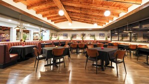 A spacious restaurant with wooden ceiling beams, multiple dining areas, and a variety of seating options including booths and tables. - Village Inn  (Lompoc)