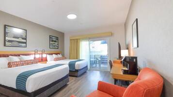 Quarto de hotel com duas camas, uma escrivaninha, uma cadeira e varanda com vista.