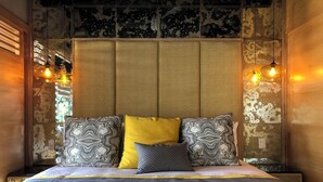 A bed with a headboard, multiple pillows, and a blanket.
