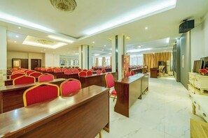 A conference room with multiple rows of red chairs, a long table, and a television on the wall. - Tongren Rujia Hotel (Tongren)