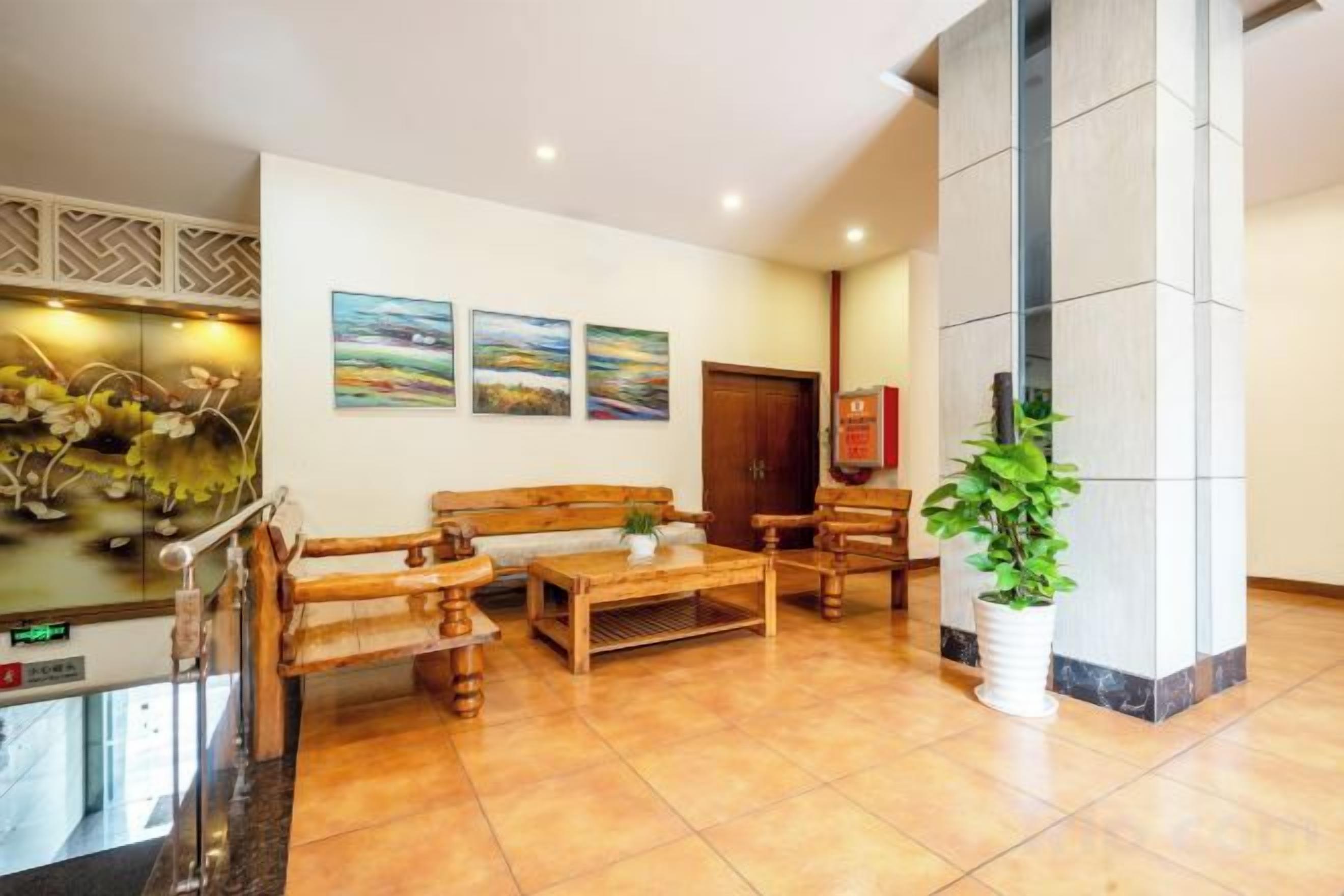 A lobby with a reception desk, seating area, and artwork on the walls.