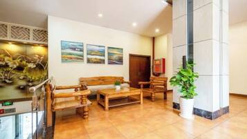 A lobby with a reception desk, seating area, and artwork on the walls.