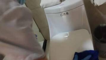 A person wearing gloves cleaning a white appliance with a blue cloth.