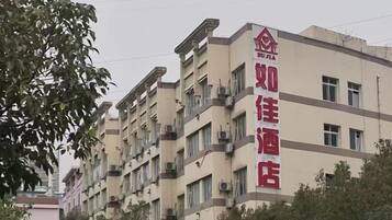 A multi-story hotel building with a prominent red sign.