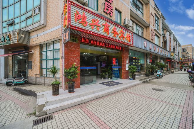 A commercial building with multiple storefronts, including a restaurant with a prominent red sign.